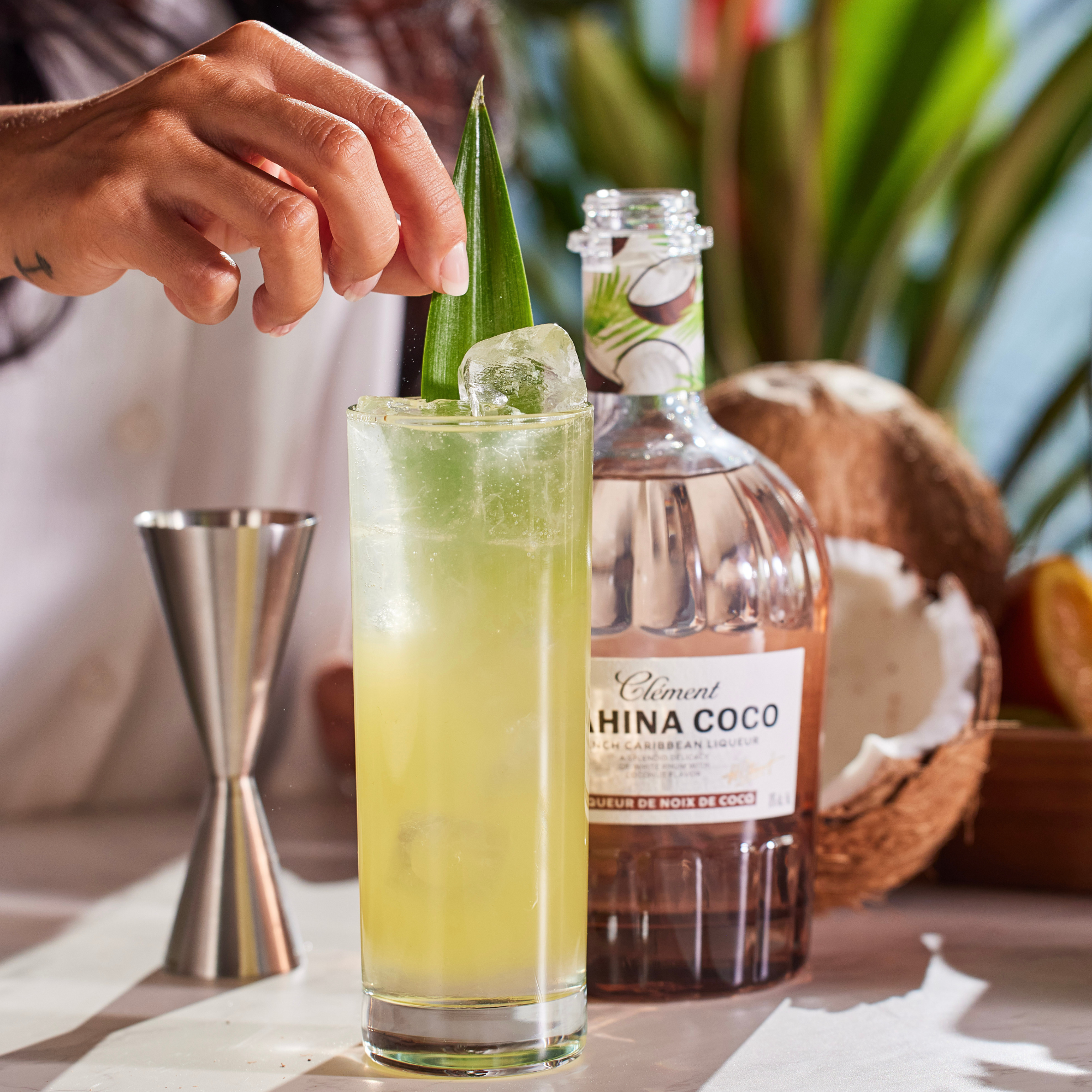 Cocktail being prepared with a bottle of Clément Ahina Coco rum.