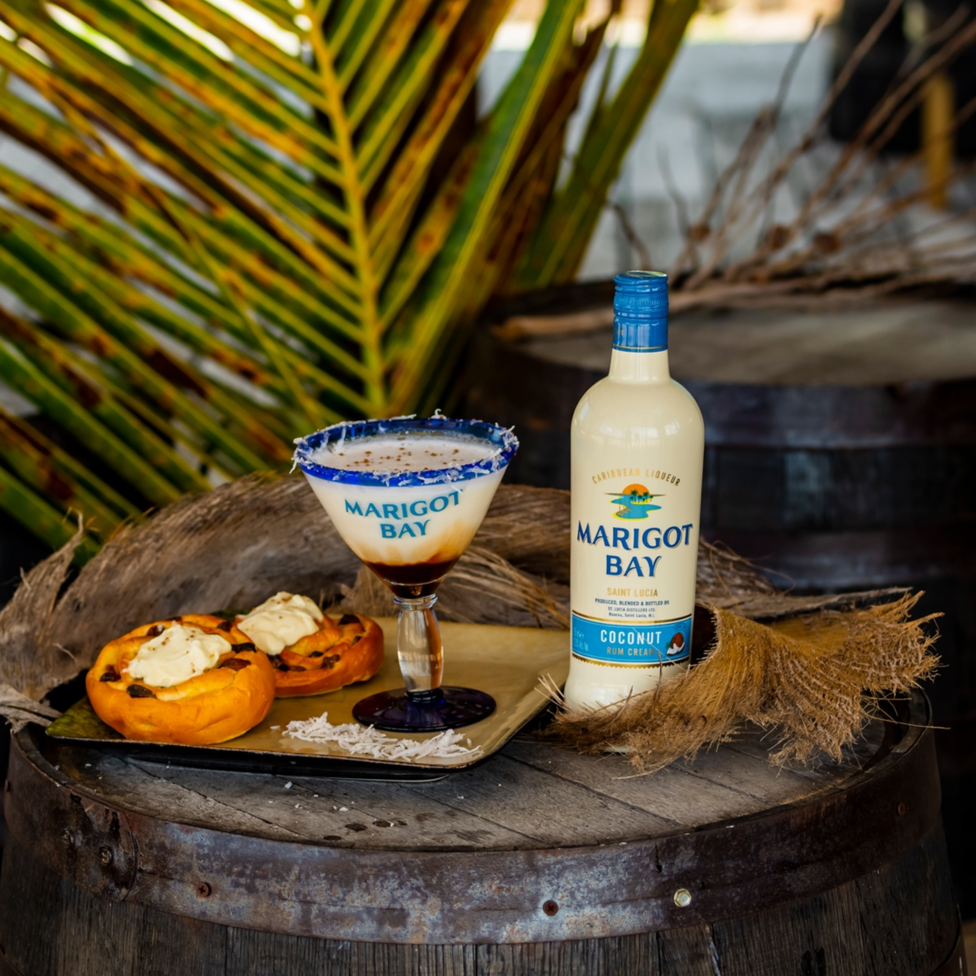 Marigot Bay coconut rum bottle with a cocktail and pumpkins on a wooden barrel