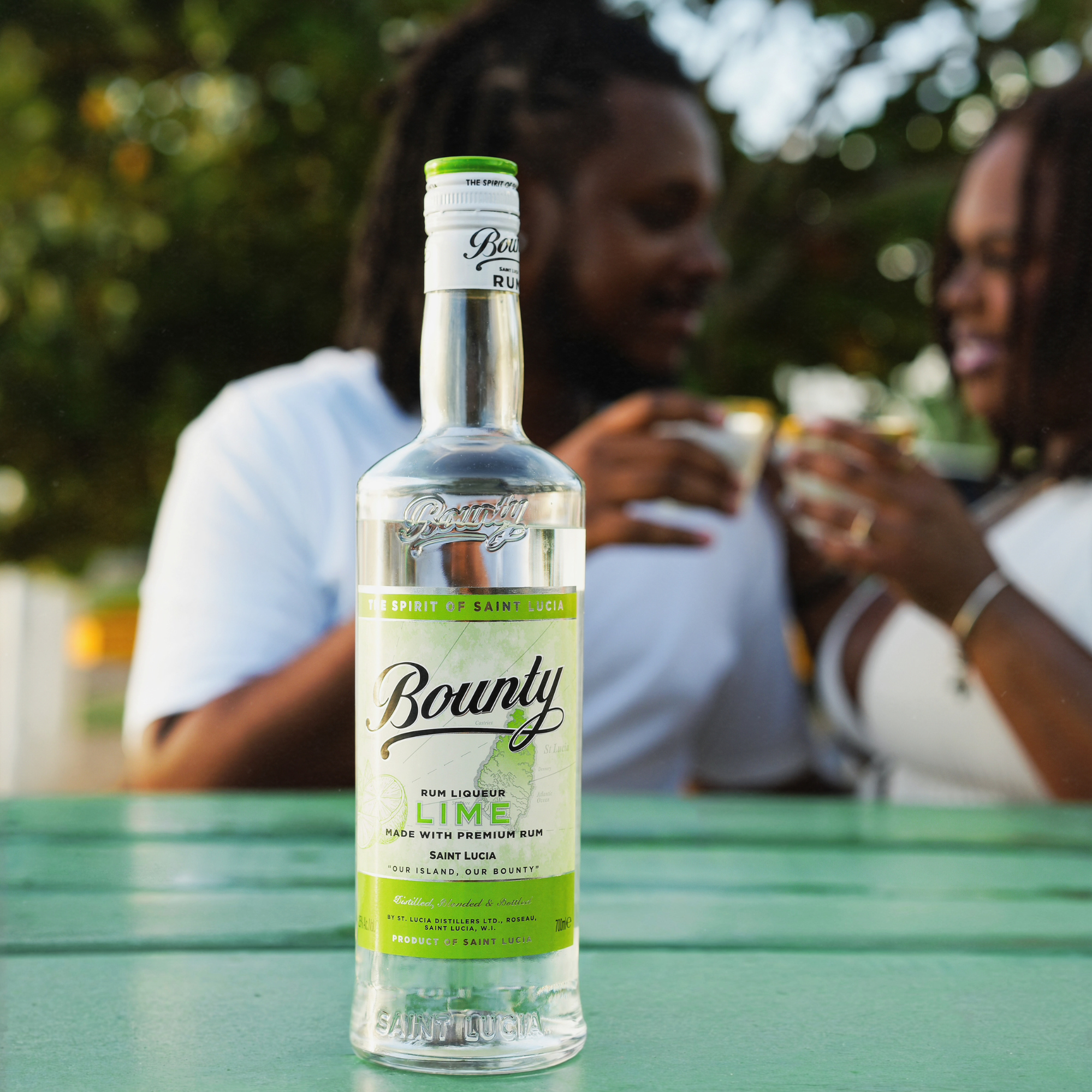 Bottle of Bounty Lime rum on a table with people in the background