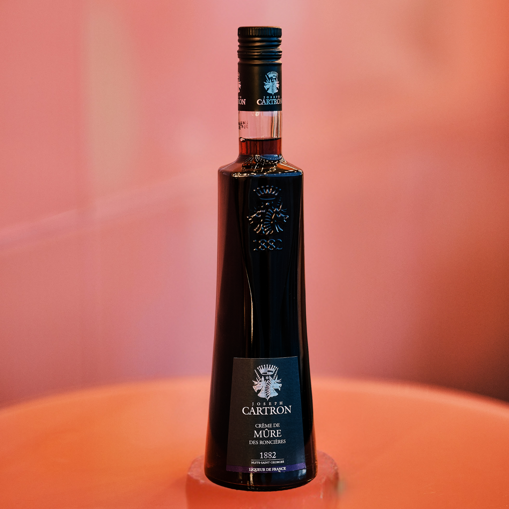Cartron Cremede Mure Blackberry Liqueur image of bottle on pink background