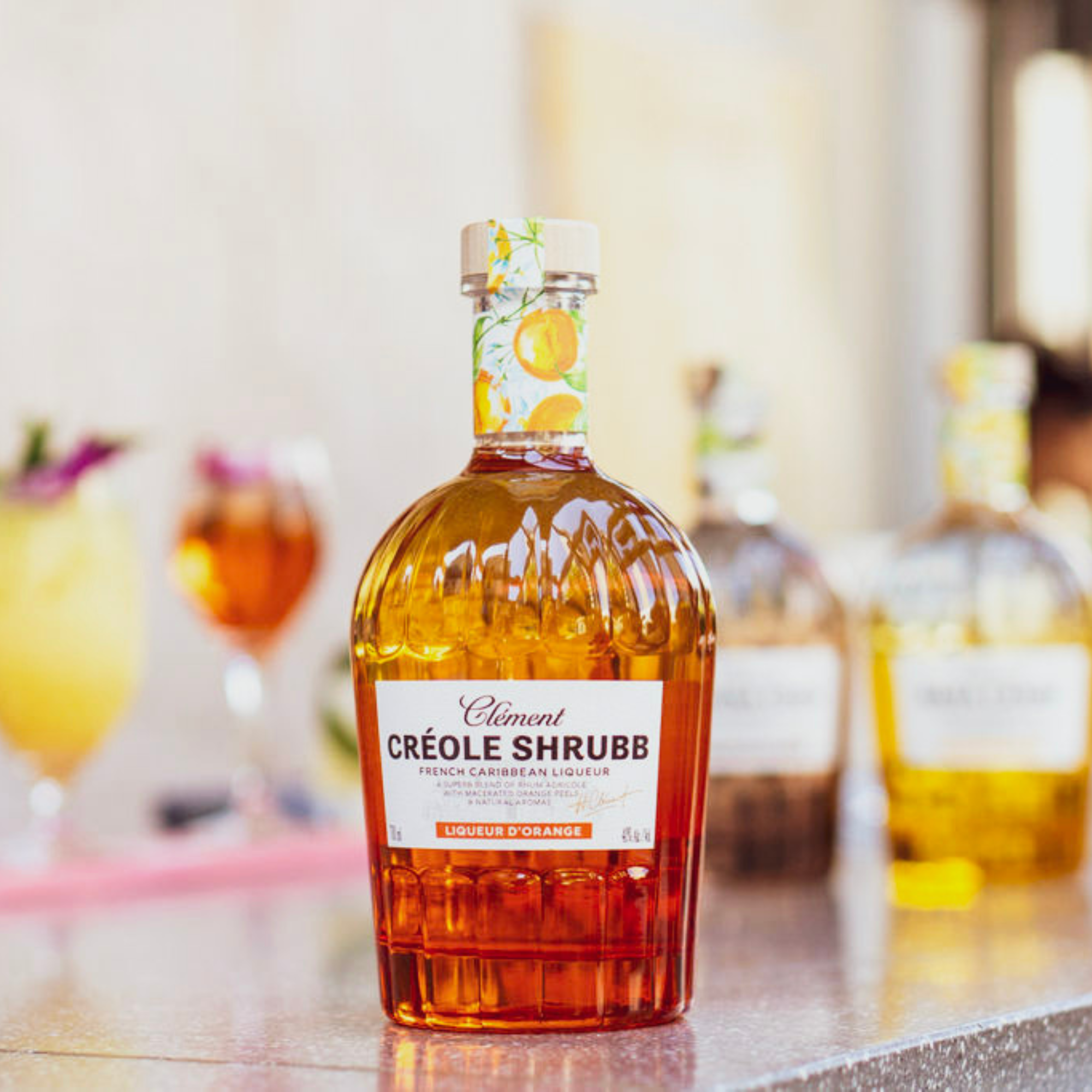 Bottle of Clément Créole Shrub on a bar counter with blurred background