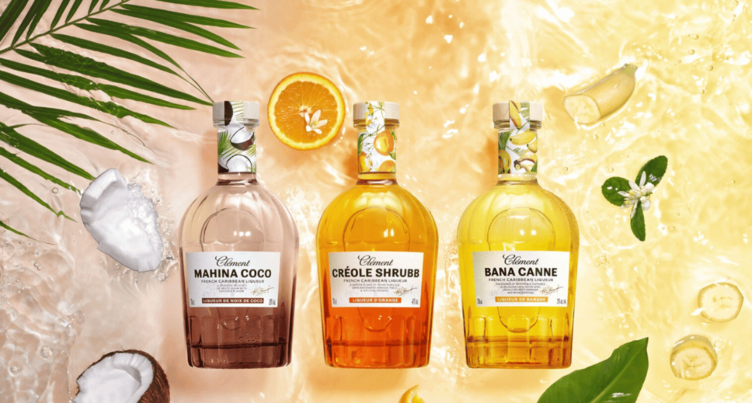 Three bottles of 'Creole Shrubs' with labels on a yellow background with orange slices and leaves.