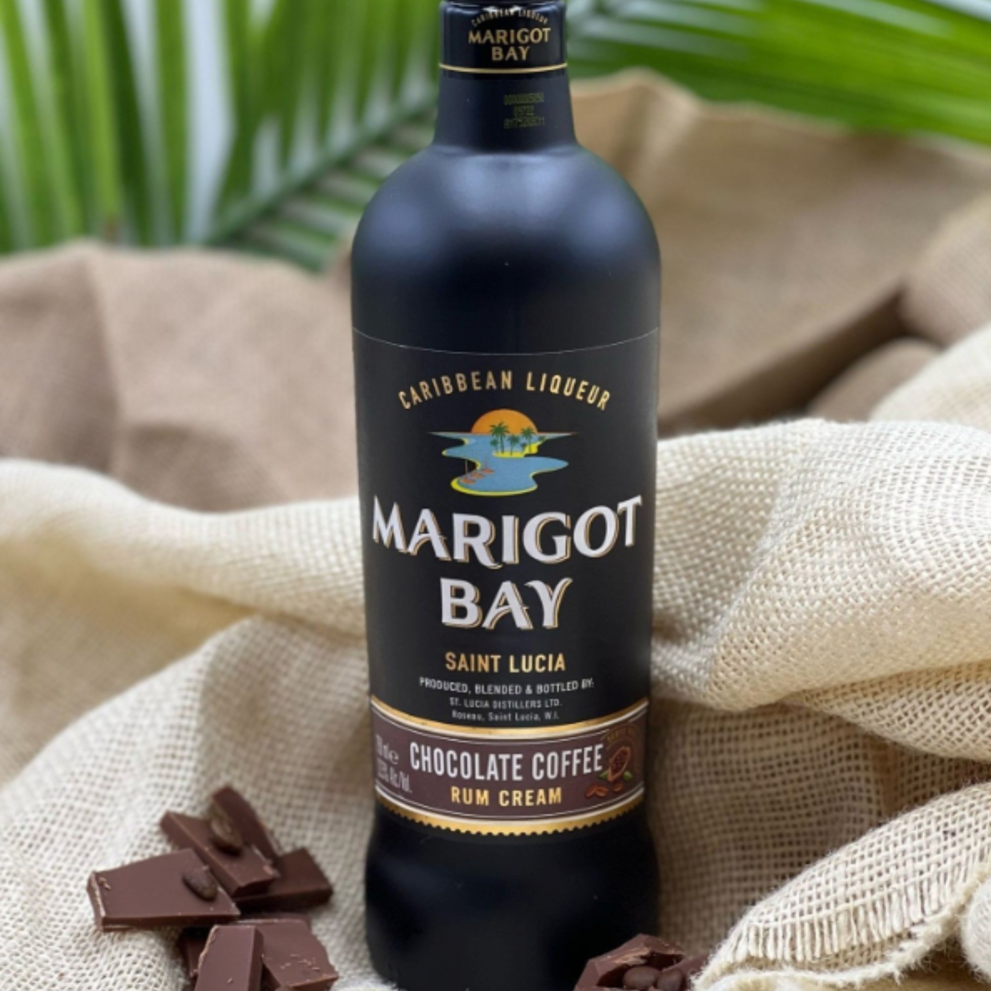 Marigot Bay rum cream bottle with chocolate pieces on a textured fabric background