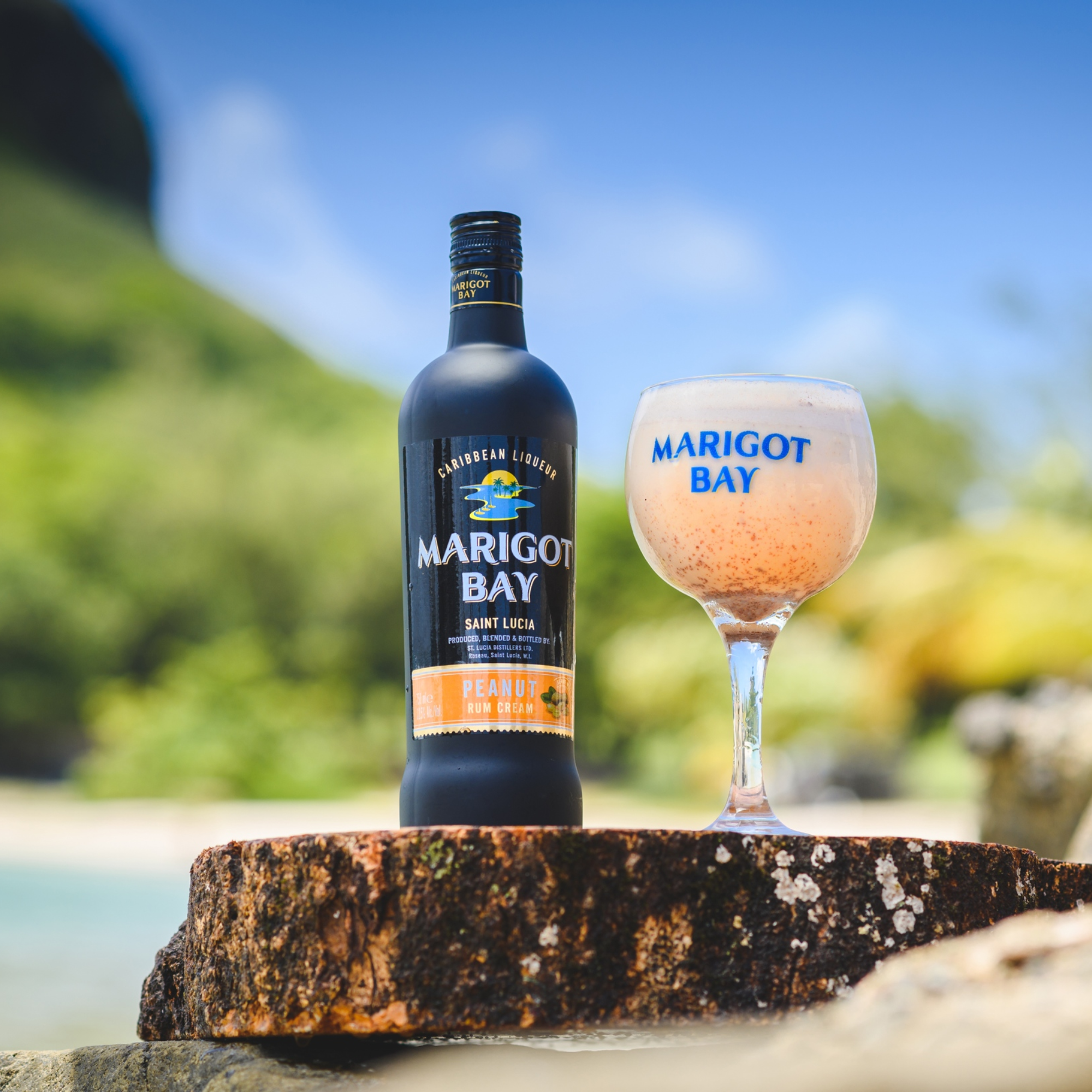 Marigot Bay rum bottle and glass with a scenic background