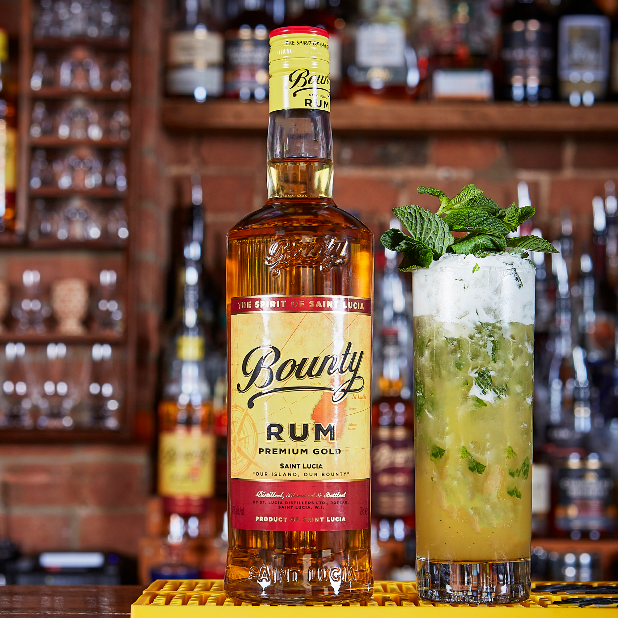 Bounty Rum bottle with a cocktail garnished with mint leaves on a bar counter.