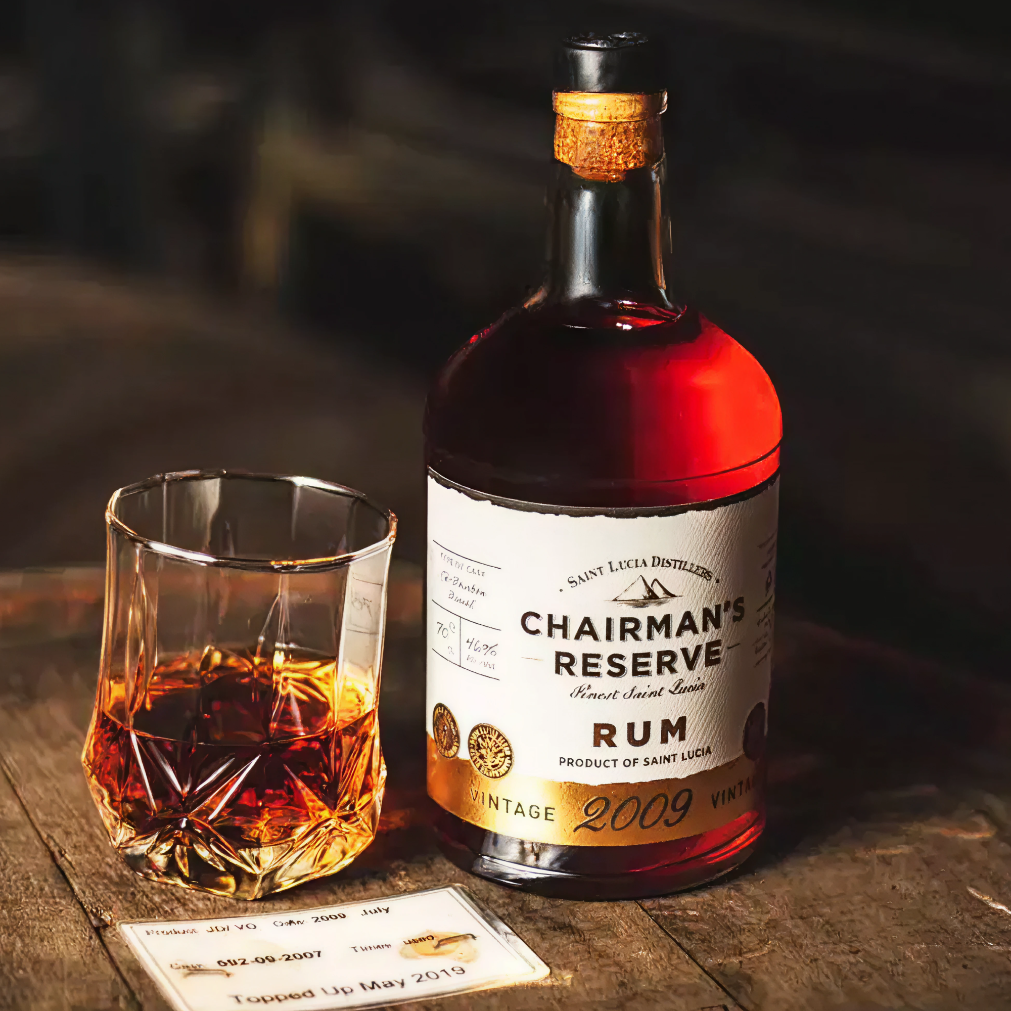Chairman's Reserve Rum bottle with a glass of rum on a wooden surface