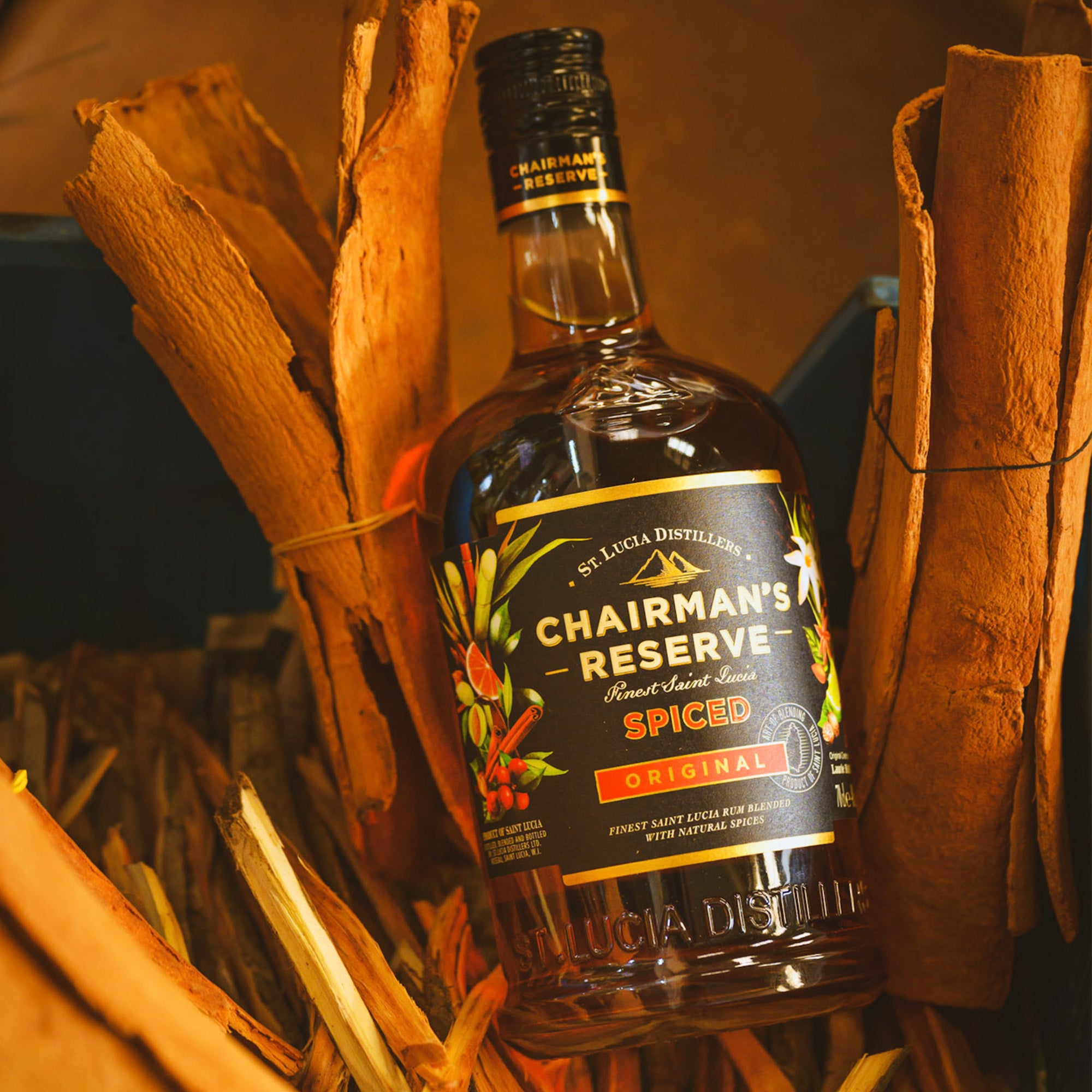 Chairman's Reserve Spiced rum bottle surrounded by cinnamon sticks and other spices.