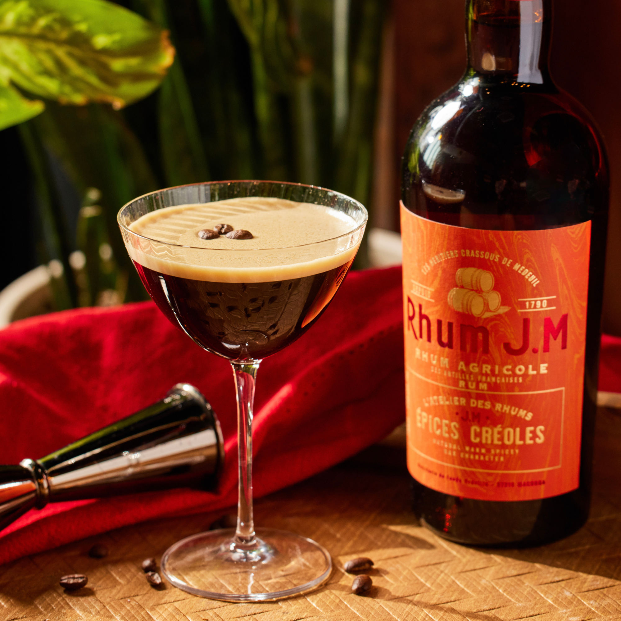 Bottle of Rhum J.M. with a cocktail on a wooden surface